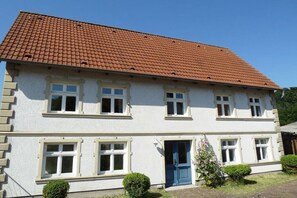 A two-story building with a red-tiled roof, white walls, and multiple windows. - Holiday apartment in Wiek with barbecue (Wiek)