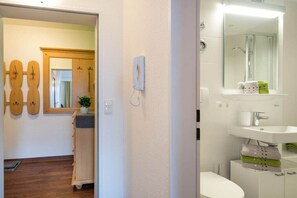 Ein Badezimmer mit Waschbecken, Spiegel und Duschbereich.