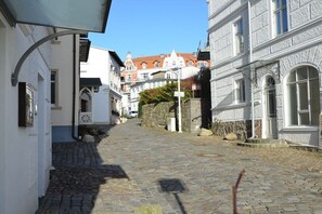 A cobblestone street with historic buildings, a stone wall, and a clear blue sky. - Villa Bernstein Apt. 32 (Binz)
