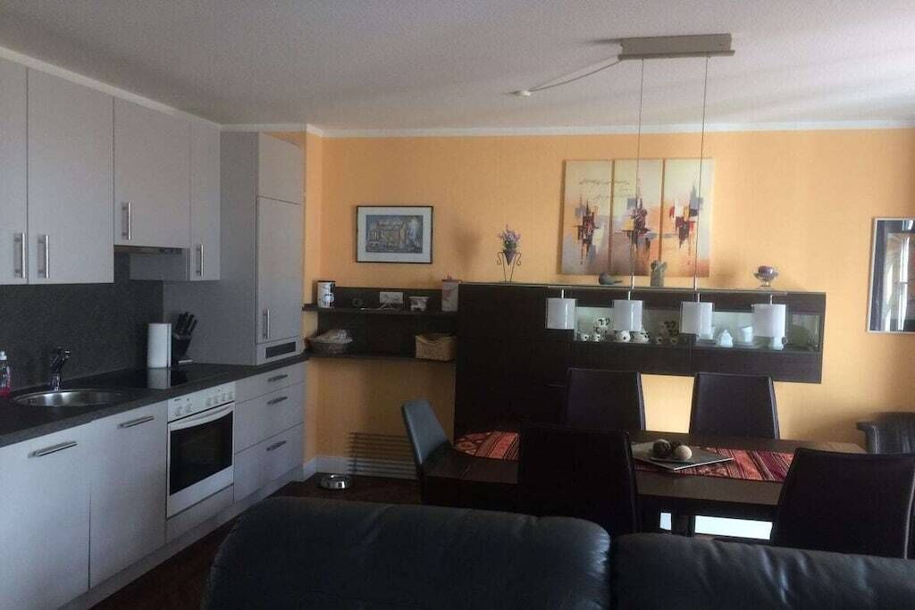 Ein kompakter Wohnraum mit Küchenzeile, Essbereich und Sitzgelegenheit.