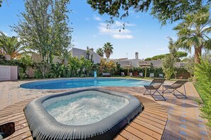 A swimming pool with a hot tub, surrounded by trees and a wooden deck. - Holiday home 'Villa Nakupenda' with private pool, Wi-Fi and air conditioning (Chiclana de la Frontera)