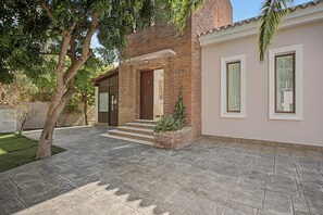 Ein Wohnhaus mit Backstein-Fassade, einem gepflasterten Einfahrt und einem gepflegten Rasen.