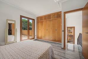 Un dormitorio con cama, armario y espejo.