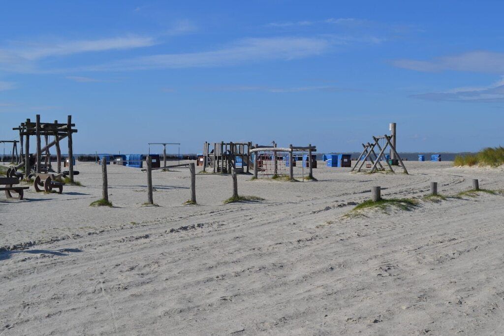 A sandy beach with wooden structures, possibly for beach games or activities.