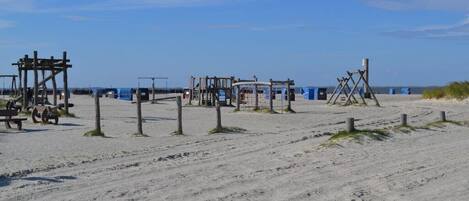 A sandy beach with wooden structures, possibly for beach games or activities.