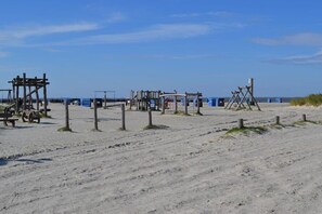 Ein sandiger Strand mit Holzbauten, vermutlich für Strandspiele oder Aktivitäten.