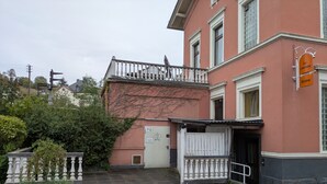Ein Gebäude mit einem weißen Balkon, einer Tür und einem Schild, das ein Restaurant anzeigt.