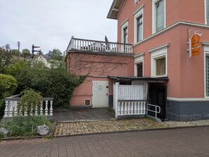 En bygning med en hvid balkon, en dør og et skilt, der angiver en restaurant.