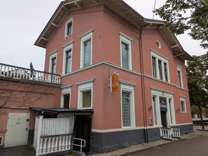 A building with a red facade, white trim, and a sign indicating a bistro.