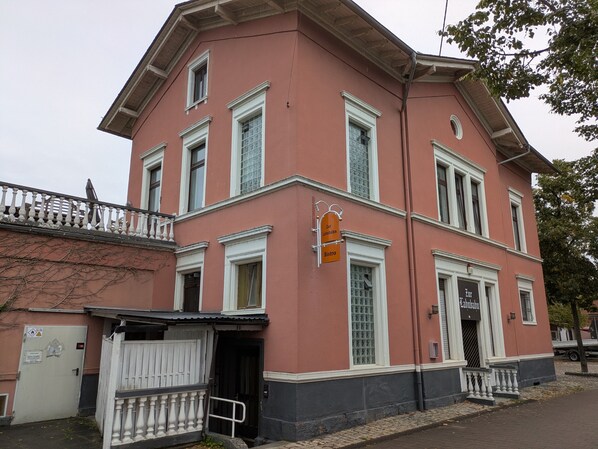 A building with a red facade, white trim, and a sign indicating a bistro.