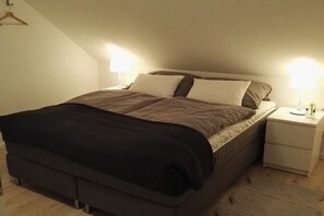 A single bed with a headboard, two bedside tables, and a nightstand with a lamp. - Semi-detached house "LUV" (Butjadingen)