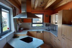 A kitchen with a stove, sink, cabinets, and a window. - Ketterer Hinterzarten Black Forest (Hinterzarten)