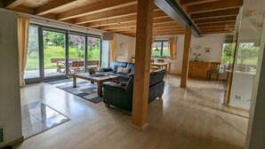 A spacious living area with a wooden ceiling, a sofa, a coffee table, and a dining area with a table and chairs. - Ketterer Hinterzarten Black Forest (Hinterzarten)