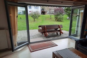 A room with a sliding glass door leading to a patio with a wooden bench and a small rug. - Ketterer Hinterzarten Black Forest (Hinterzarten)
