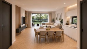A modern living room with a dining area, large windows, and a kitchen.