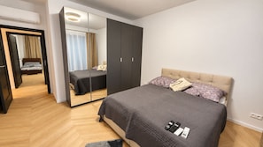 Una camera da letto con un letto, comodini, un armadio e uno specchio.