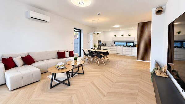 Una sala de estar moderna con sofá, mesa de centro y comedor.