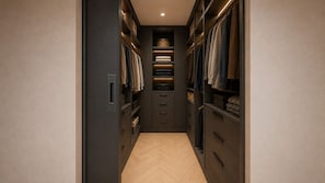 A narrow walk-through closet with shelves and drawers, featuring neatly folded clothes and storage boxes.