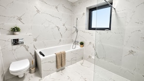 Un bagno moderno con vasca, servizi igienici e doccia.