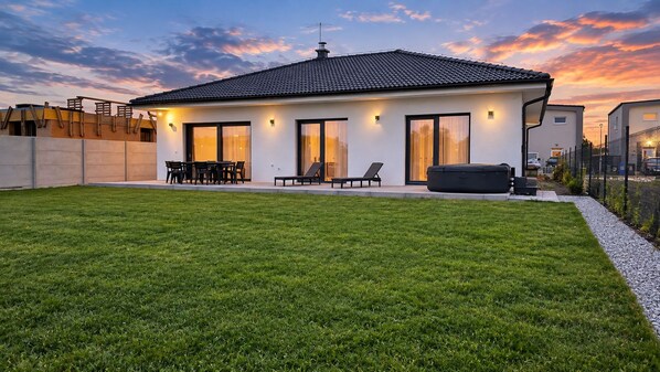 Una casa moderna con techo plano, ventanas amplias y un césped bien cuidado.