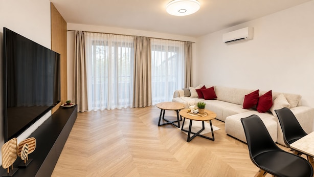 Uma sala de estar moderna com um sofá, duas poltronas, uma mesa de centro e uma televisão.
