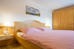 Una camera da letto con un letto in legno, due lampade da comodino, un comodino e un armadio.