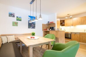 Una cucina moderna con mobili in legno, un tavolo da pranzo con sedie e una panca.