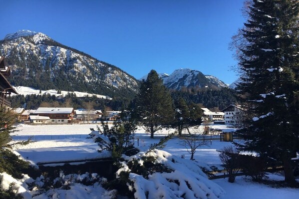 Paesaggio montuoso innevato con edifici in primo piano.