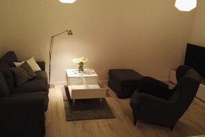 Ein Wohnzimmer mit einer Couch, einem Couchtisch und einem Sessel.