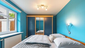 Une chambre à coucher avec un lit, une fenêtre et un miroir.