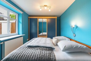 Une chambre à coucher avec un lit, une fenêtre et un miroir.