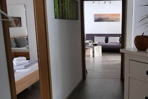 Une chambre d’hôtel avec un lit, un canapé, une petite table avec une plante et un tableau au mur.