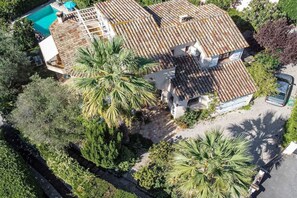 A two-story house with a tiled roof, surrounded by lush greenery and a swimming pool. - Villa in Vence with swimming pool (Vence)