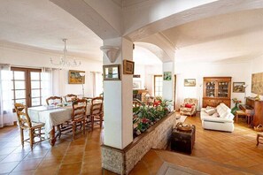 A spacious living area with a dining table, chairs, a sofa, and a cabinet. - Villa in Vence with swimming pool (Vence)