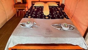 Uma tenda com cama, mesa e cadeira.