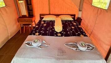 Una carpa con una cama, una mesa y una silla.