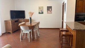 Een knus keuken met een eethoek, een televisie en een kleine bar.