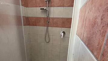 Eine Dusche mit Handbrause und Wandarmatur.