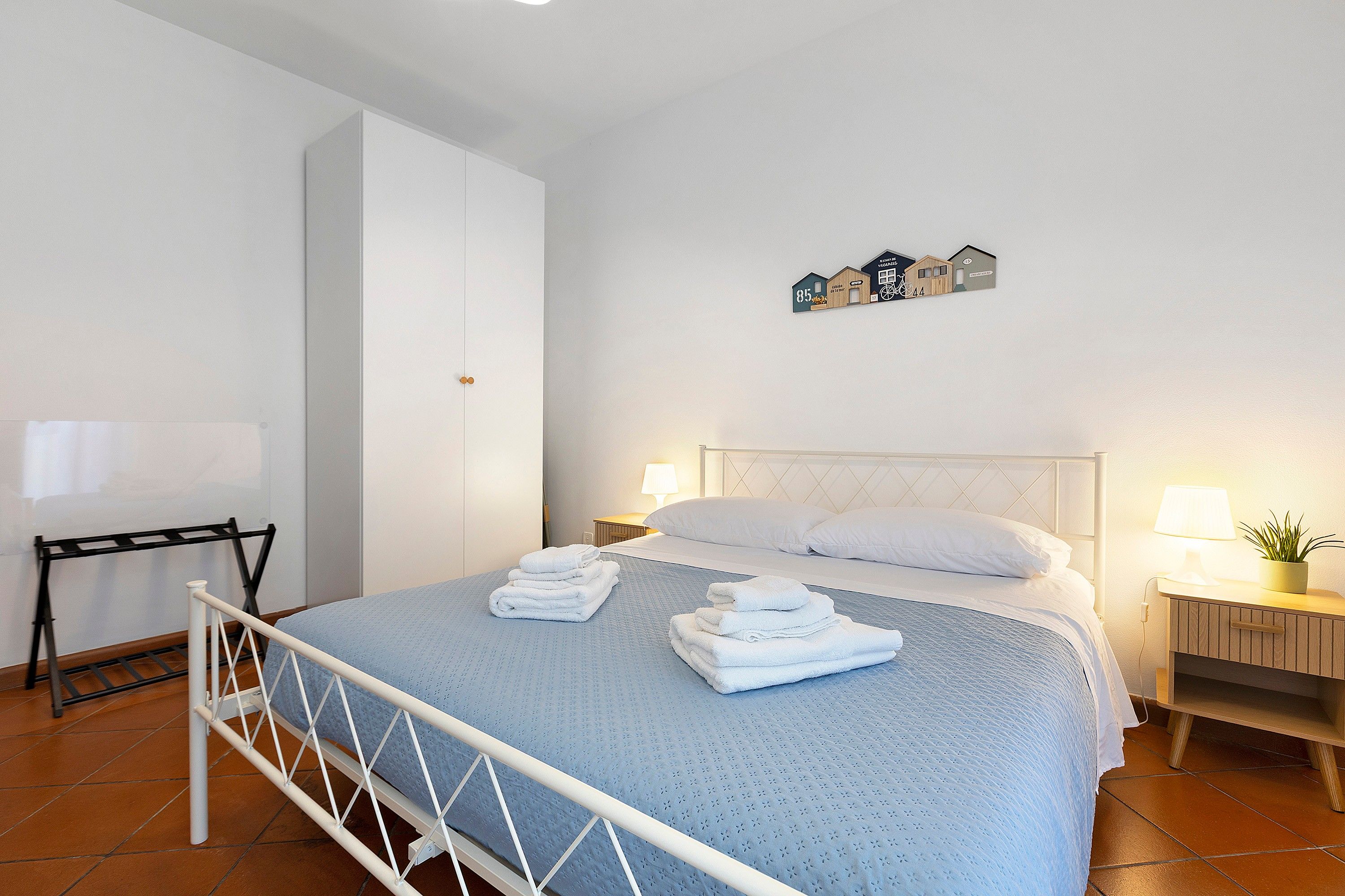 Ein Hotelzimmer mit einem Bett, zwei Nachttischen, einer Wanddekoration und einem Heizkörper.