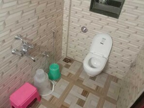 A bathroom with a toilet, a shower, and a sink. - Hotel Sai Krupa (Mahad)