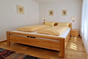 Ein Schlafzimmer mit einem hölzernen Bett, Nachttischen und Wandlampen.