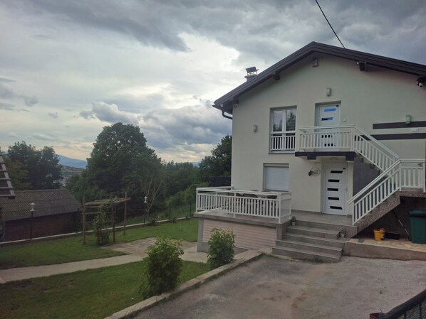 A two-story building with a balcony, a staircase, and a small garden area. - Private Family House with Garden & Gazebo Sleeps 10 Sarajevo (Sarajevo)