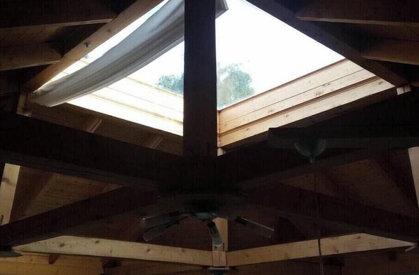 Ein Zimmer mit schrägen Wänden und einem Dachfenster.