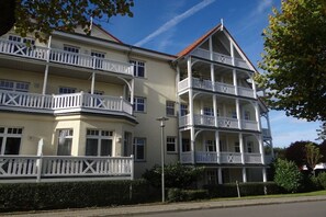 A multi-story building with balconies, a red roof, and a clear sky. - Villa Parkblick Apt. 17 (Kühlungsborn)