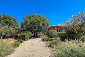 A gravel path leading to a house with a red roof, surrounded by various trees and shrubs. - Holiday home in Aups with swimming pool (Aups)
