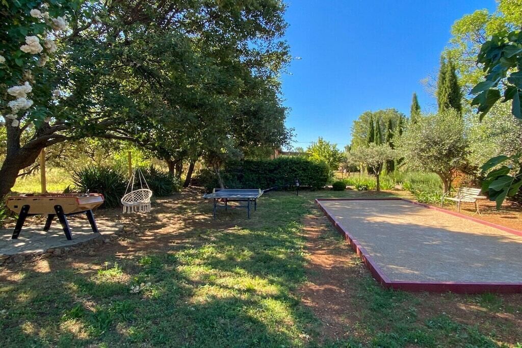 A garden with a paved area, benches, and trees.