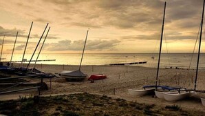 Uma praia com barcos e um cais.