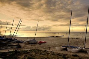 Una playa con barcos y un muelle.