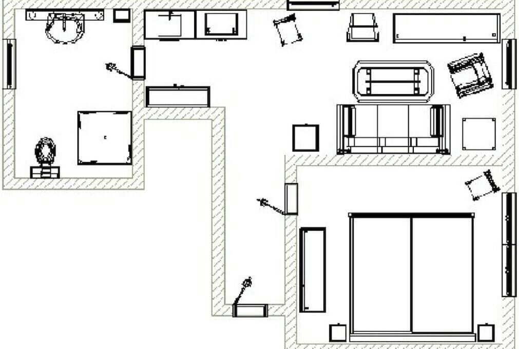 Disposição de um quarto de hotel, incluindo uma cama, área de estar e banheiro.