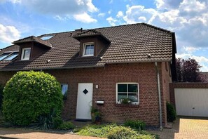 A two-story brick house with a sloped roof, a front door, and a small window. - Holiday home in Rees with swimming pool (Rees)